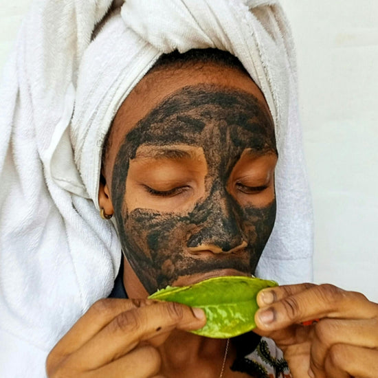 Person with a white towel on their head holding a green leaf