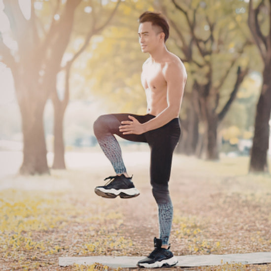 Man exercising outdoors in a park with trees and sunlight